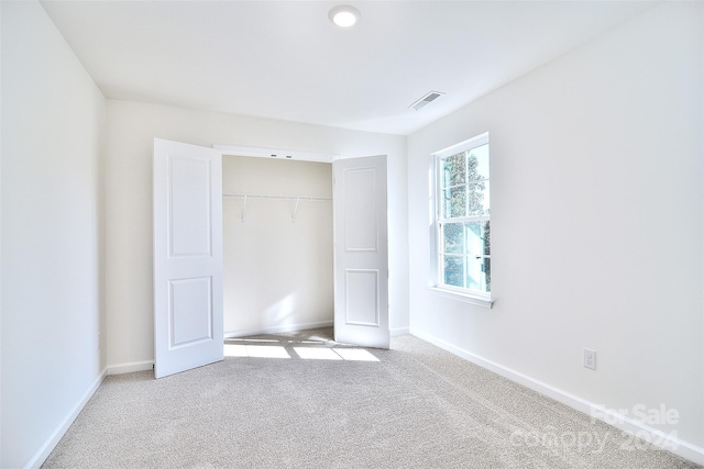 unfurnished bedroom with a closet and light carpet