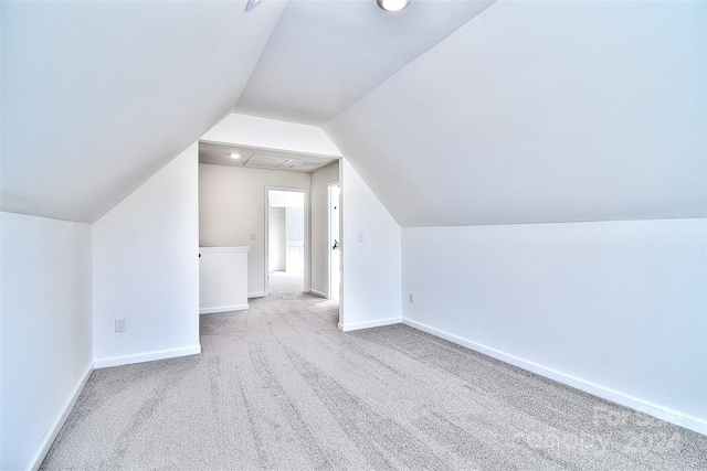 additional living space with vaulted ceiling and light colored carpet