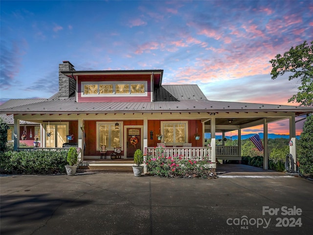 view of front of property with covered porch and a carport