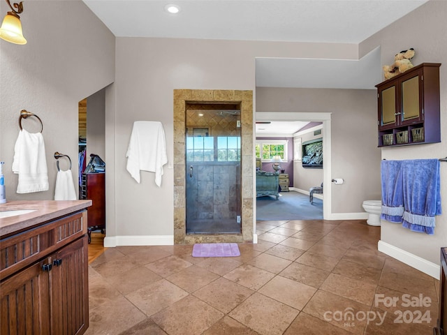 bathroom featuring vanity, toilet, a tile shower, and tile patterned floors