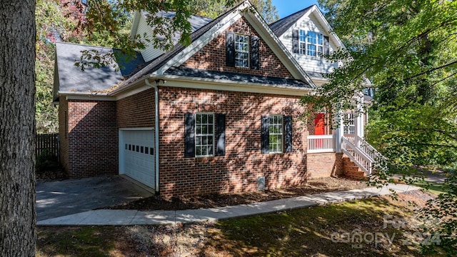 view of front of home featuring brick siding, driveway, roof with shingles, and a garage