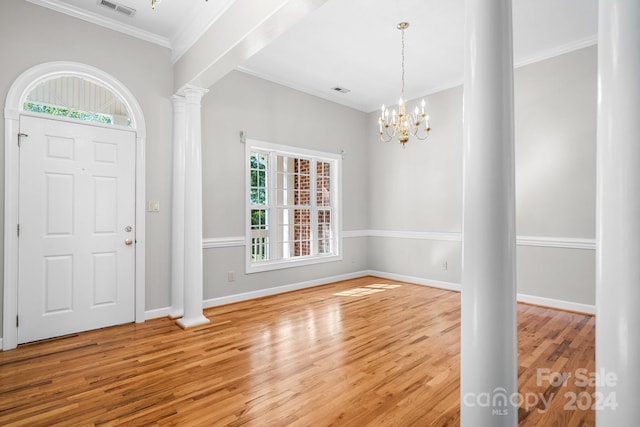 foyer featuring crown molding, a notable chandelier, hardwood / wood-style flooring, and plenty of natural light