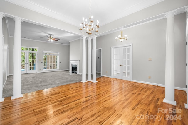 unfurnished living room featuring french doors, ornamental molding, light colored carpet, and ceiling fan with notable chandelier