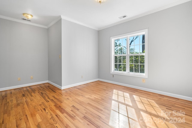 unfurnished room featuring hardwood / wood-style floors and crown molding