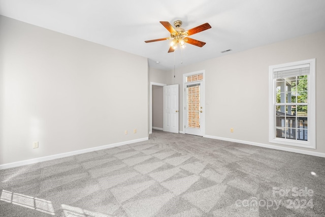 carpeted spare room with ceiling fan