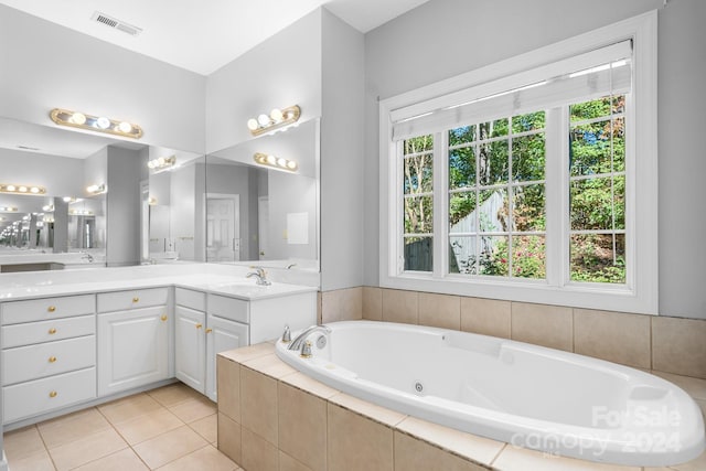 bathroom with vanity, tile patterned flooring, and tiled tub