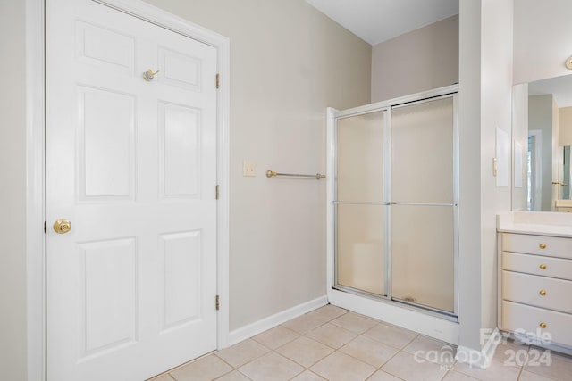 bathroom with vanity, a shower with shower door, and tile patterned flooring