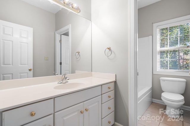 bathroom with vanity, toilet, a bathtub, and tile patterned floors