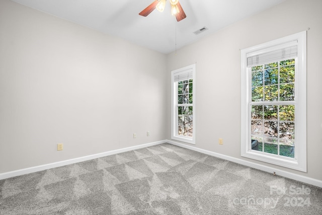 unfurnished room with visible vents, baseboards, carpet floors, and ceiling fan