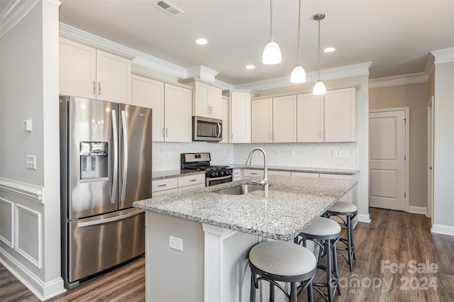 kitchen with a center island with sink, stainless steel appliances, dark hardwood / wood-style flooring, light stone countertops, and sink