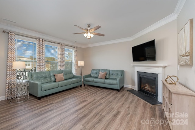 living room with hardwood / wood-style flooring, ceiling fan, and ornamental molding