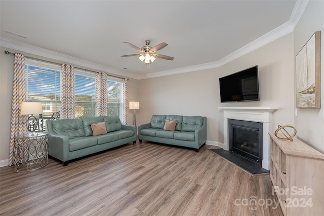 living room featuring hardwood / wood-style floors, ceiling fan, and crown molding