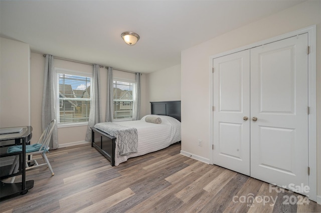 bedroom with light hardwood / wood-style flooring and a closet