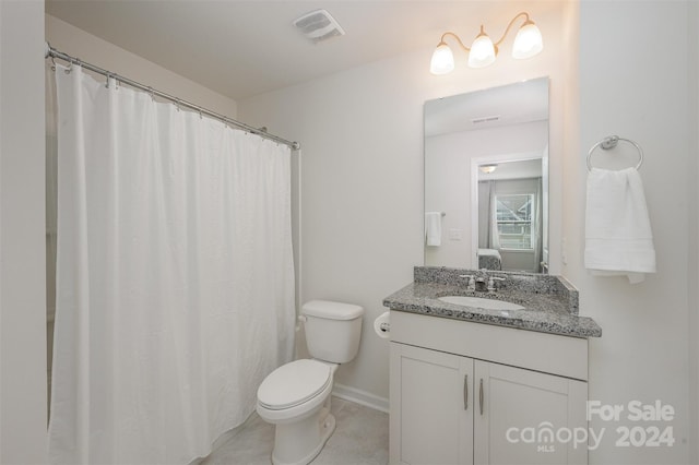 bathroom featuring toilet, vanity, a shower with shower curtain, and tile patterned flooring