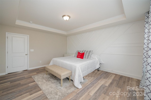 bedroom featuring wood-type flooring and a tray ceiling