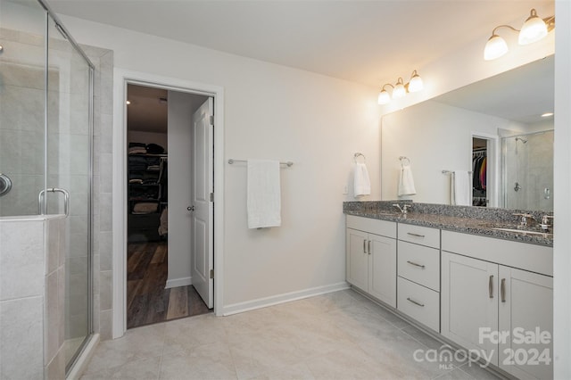 bathroom with an enclosed shower, vanity, and wood-type flooring