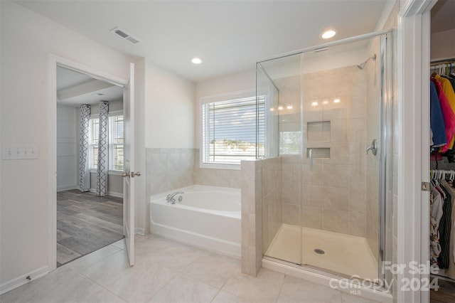 bathroom featuring hardwood / wood-style floors and plus walk in shower