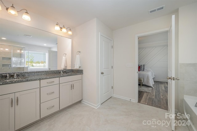 3057 Burnello Ct, Iron Station, NC 28080 - full bathroom featuring double vanity, a bathtub, tile patterned floors, and baseboards