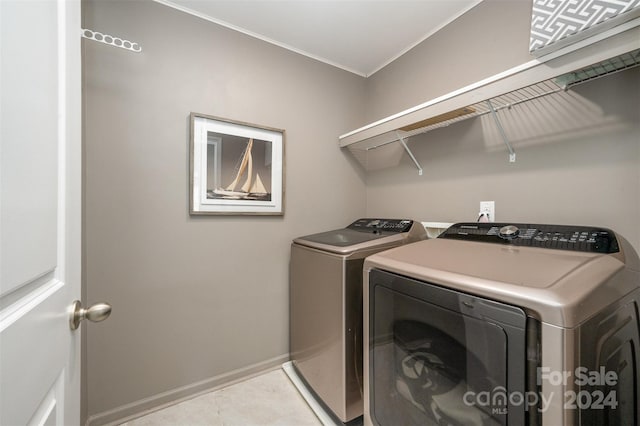 clothes washing area with ornamental molding and separate washer and dryer