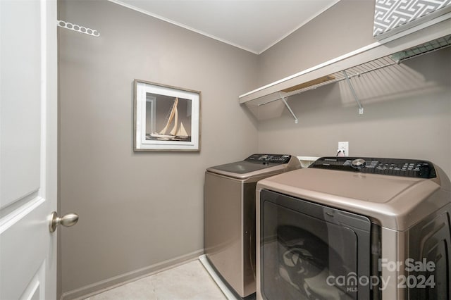 3057 Burnello Ct, Iron Station, NC 28080 - laundry area featuring washing machine and clothes dryer, ornamental molding, baseboards, and light tile patterned floors