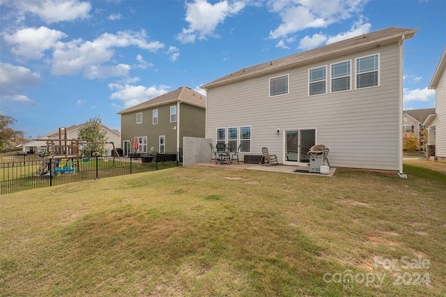 rear view of house with a lawn and a patio