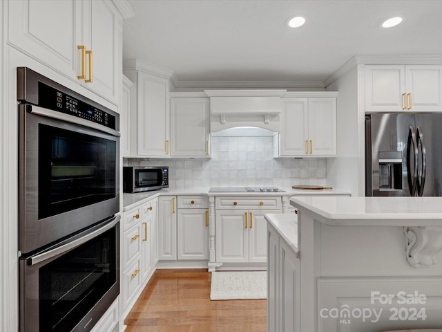 kitchen featuring light hardwood / wood-style floors, appliances with stainless steel finishes, decorative backsplash, and white cabinets