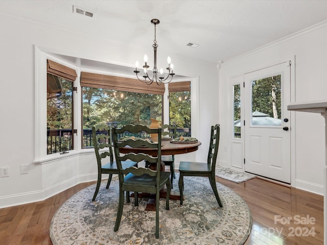 dining space featuring a notable chandelier, hardwood / wood-style floors, and crown molding