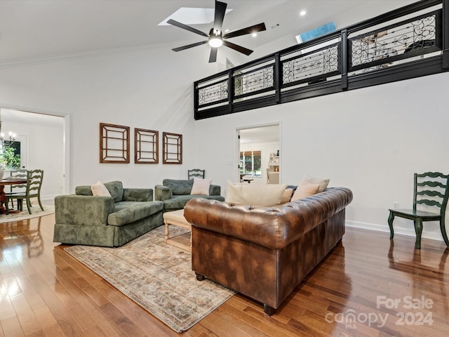 living room featuring high vaulted ceiling, hardwood / wood-style flooring, crown molding, and ceiling fan with notable chandelier