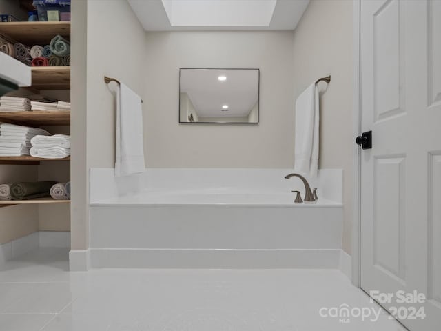 bathroom with tile patterned floors and a bath