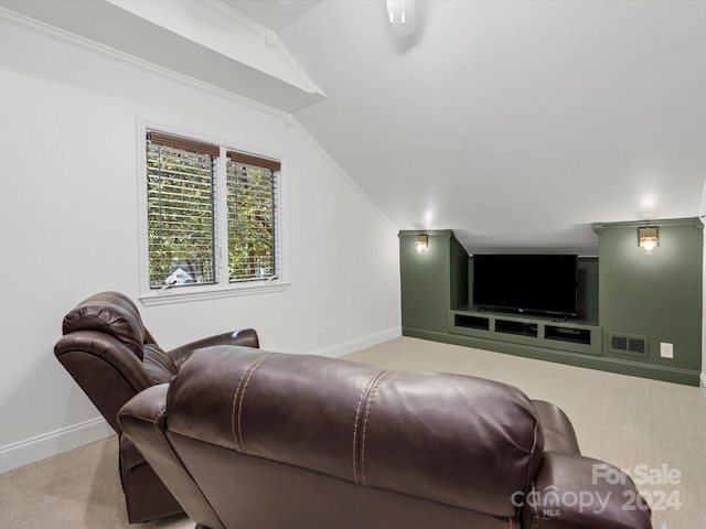 carpeted home theater with lofted ceiling and crown molding