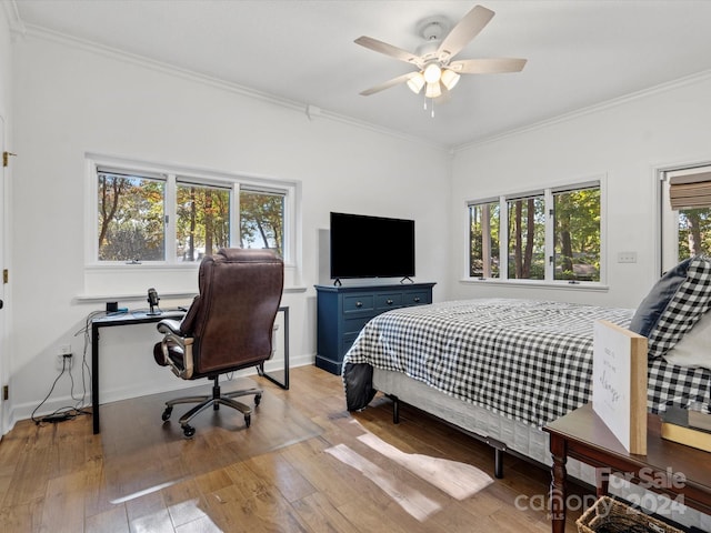 bedroom featuring crown molding, light wood-type flooring, and ceiling fan