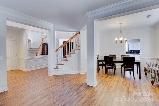 dining room featuring an inviting chandelier, ornamental molding, and light hardwood / wood-style floors