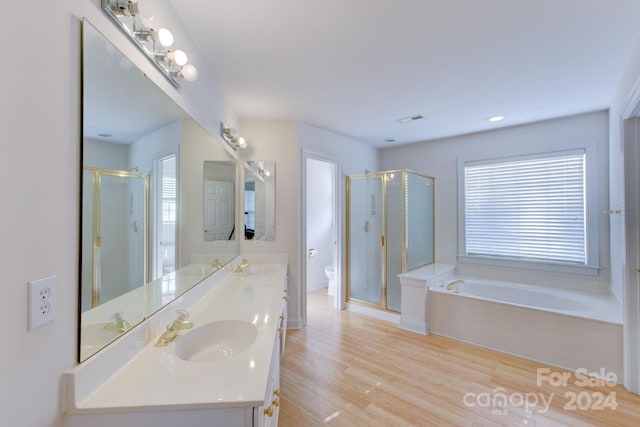 full bathroom featuring toilet, shower with separate bathtub, and plenty of natural light