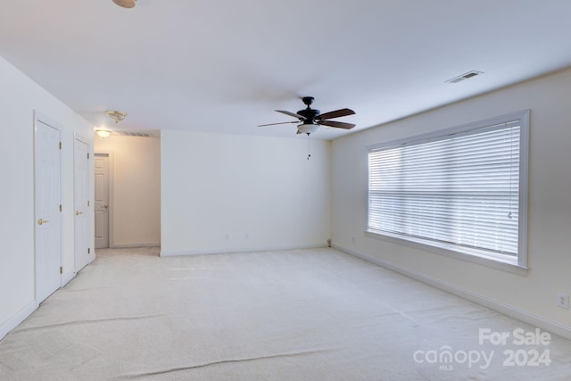 carpeted spare room featuring ceiling fan