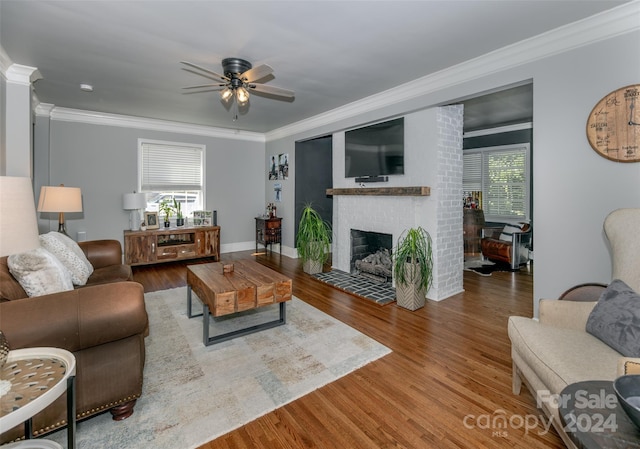 living room featuring a wealth of natural light, wood-type flooring, and crown molding