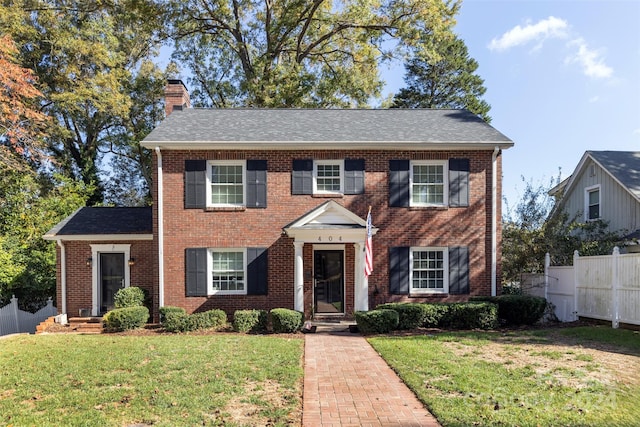 colonial home featuring a front lawn