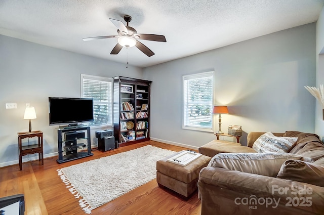 living room featuring hardwood / wood-style floors, a textured ceiling, and ceiling fan