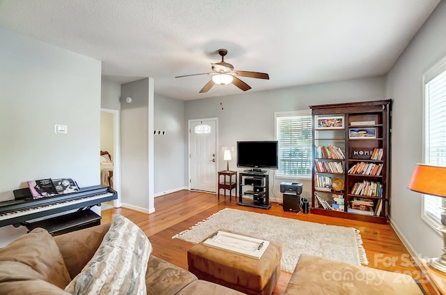 living room featuring a textured ceiling, hardwood / wood-style flooring, a wealth of natural light, and ceiling fan