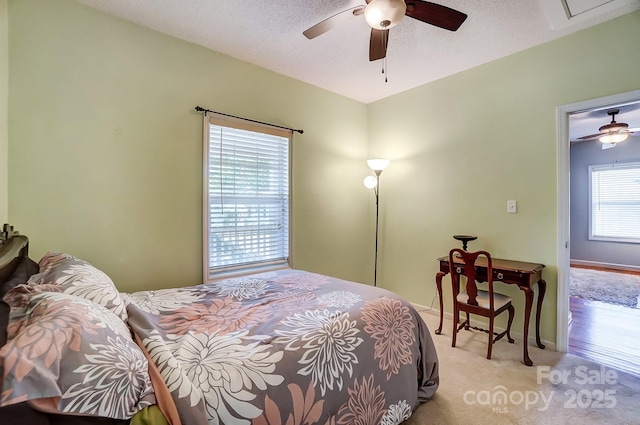 carpeted bedroom with a textured ceiling and ceiling fan