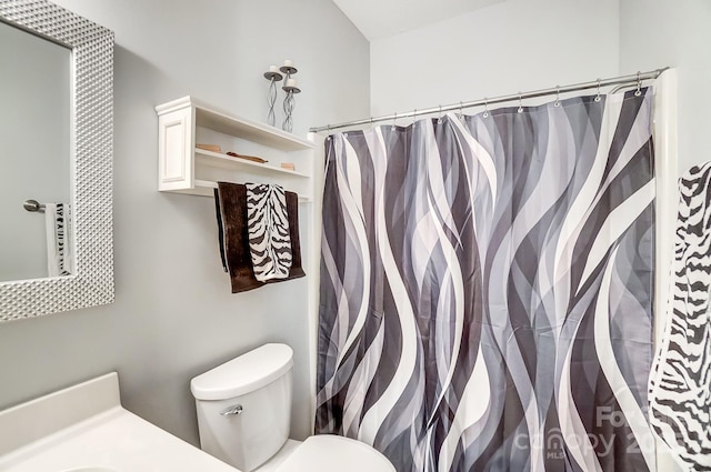 bathroom with curtained shower, vanity, and toilet