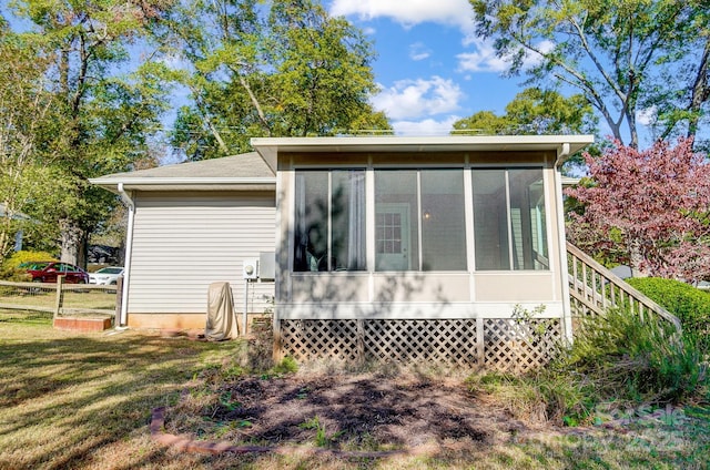 view of property exterior with a sunroom and a yard