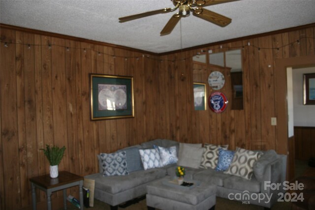 316 N Government St, Lincolnton, NC 28092 - living room with ceiling fan, wood walls, a textured ceiling, and crown molding