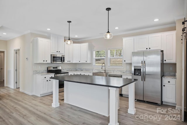 kitchen with white cabinets, decorative light fixtures, and stainless steel appliances