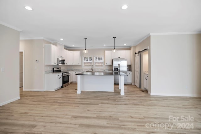 kitchen featuring a center island, a barn door, white cabinetry, and appliances with stainless steel finishes