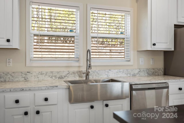 kitchen featuring light stone counters, sink, white cabinets, and stainless steel dishwasher