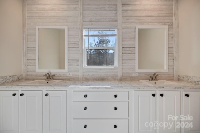 bathroom featuring vanity and wooden walls