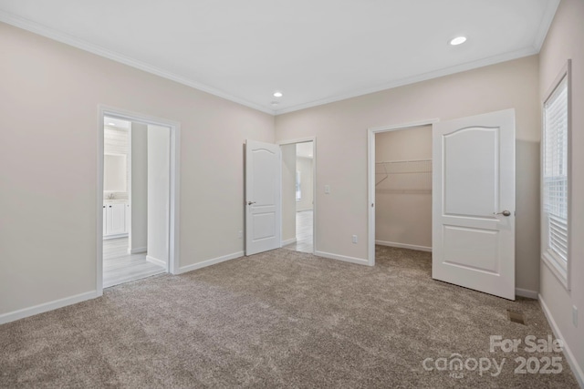 unfurnished bedroom with carpet, crown molding, recessed lighting, a spacious closet, and baseboards