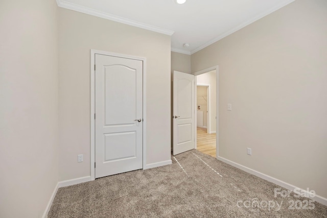 unfurnished bedroom featuring light carpet, baseboards, and crown molding