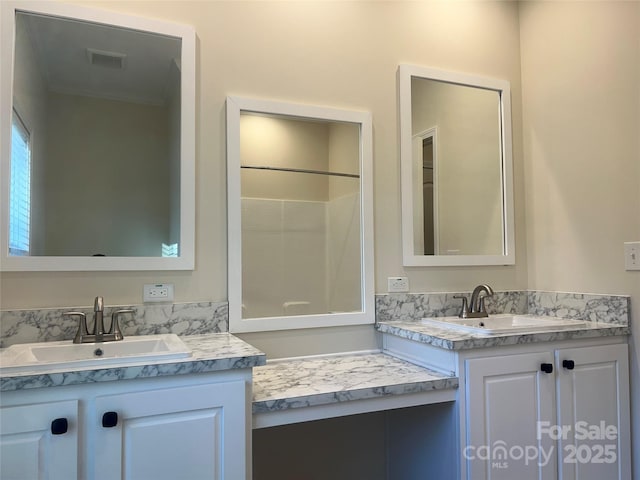 full bath with visible vents, two vanities, and a sink