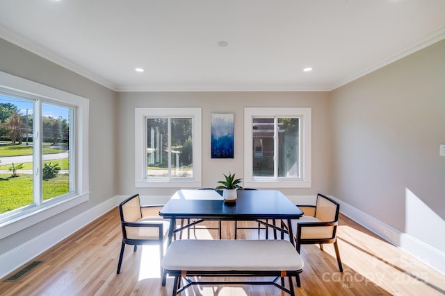 dining room featuring light wood-type flooring and crown molding